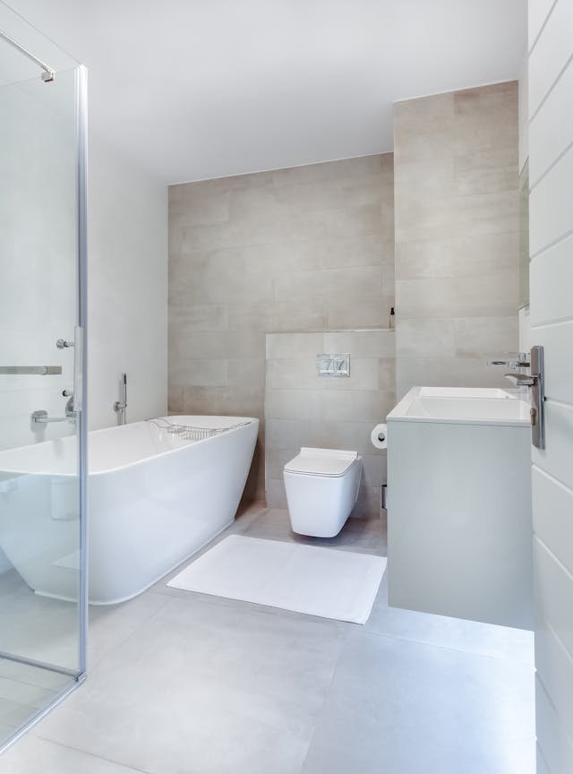 Minimalist bathroom with floating sink, glass shower, and freestanding tub.
